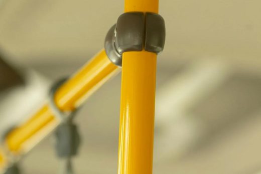 Barres métal jaunes et connecteurs noirs, savoir-faire métallurgie Côte d'Azur, détails transports publics.