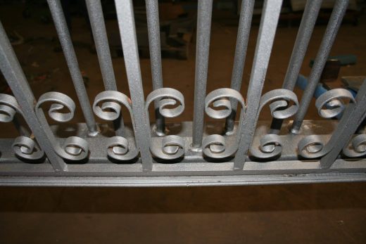 Barrière métallique thermolaquée, barreaux verticaux, volutes décoratives, finition CRC Antibes.