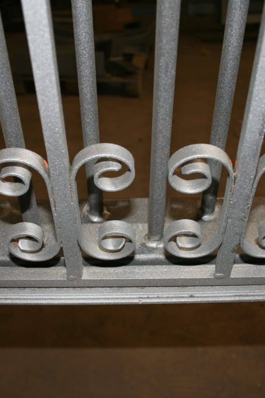 Barrière métallique thermolaquée, barreaux verticaux, volutes décoratives, finition CRC Antibes.