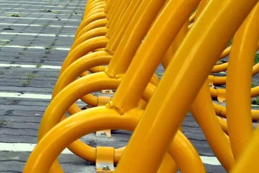 Racks vélo métal jaune thermolaqués, alignés sur trottoir, savoir-faire CRC Antibes depuis 30 ans.